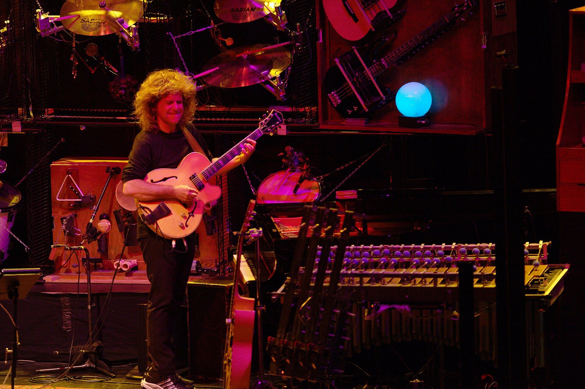 Pat Metheny on stage surrounded by the mechanical instruments of the Orchestrion