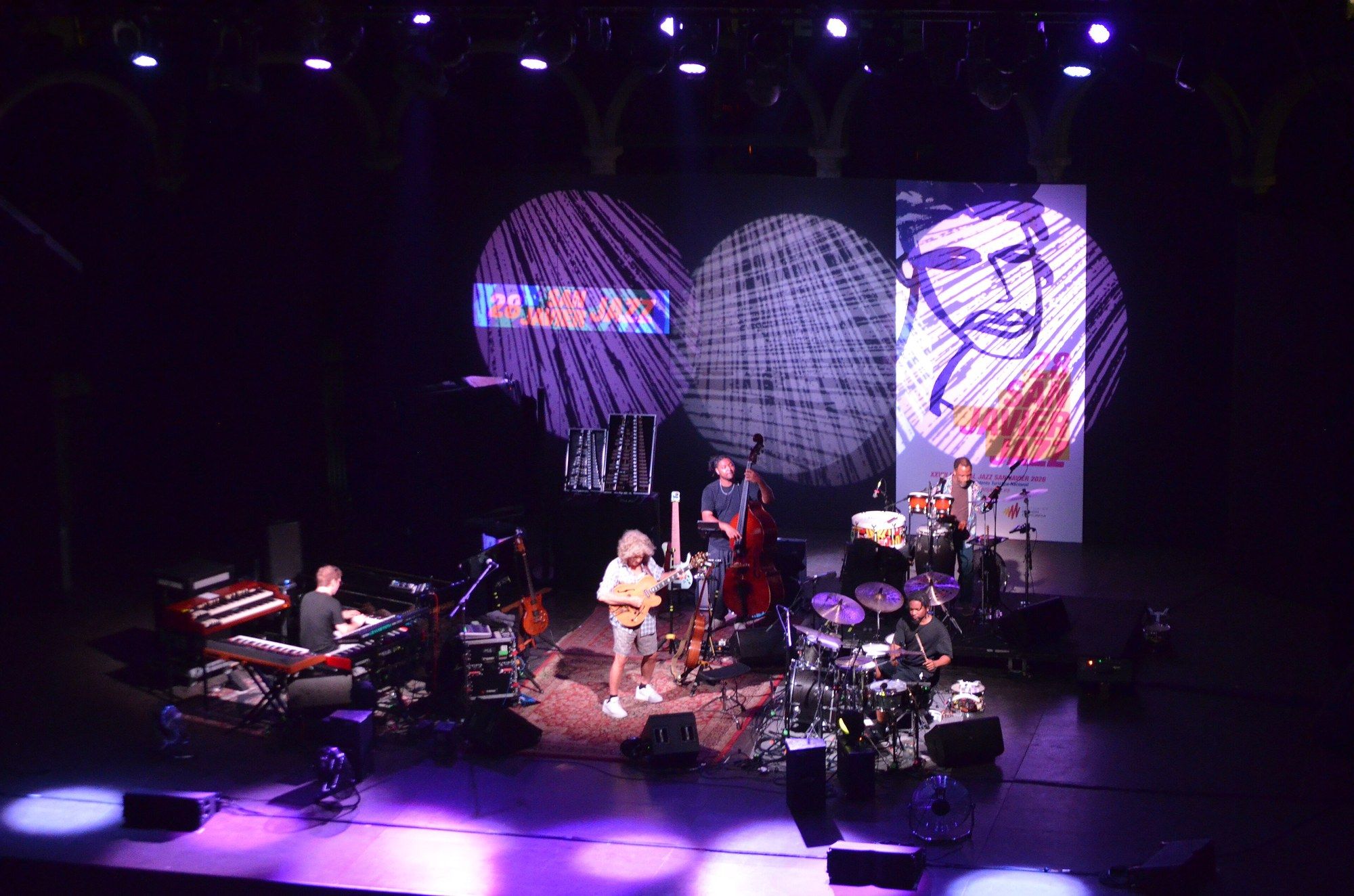 The full Side-Eye III band on stage at San Javier in front of large projected artwork