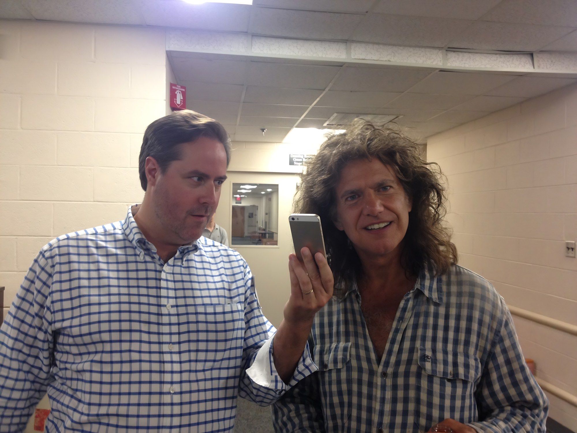 Pat Metheny laughing and holding up a phone next to Sean Fenlon