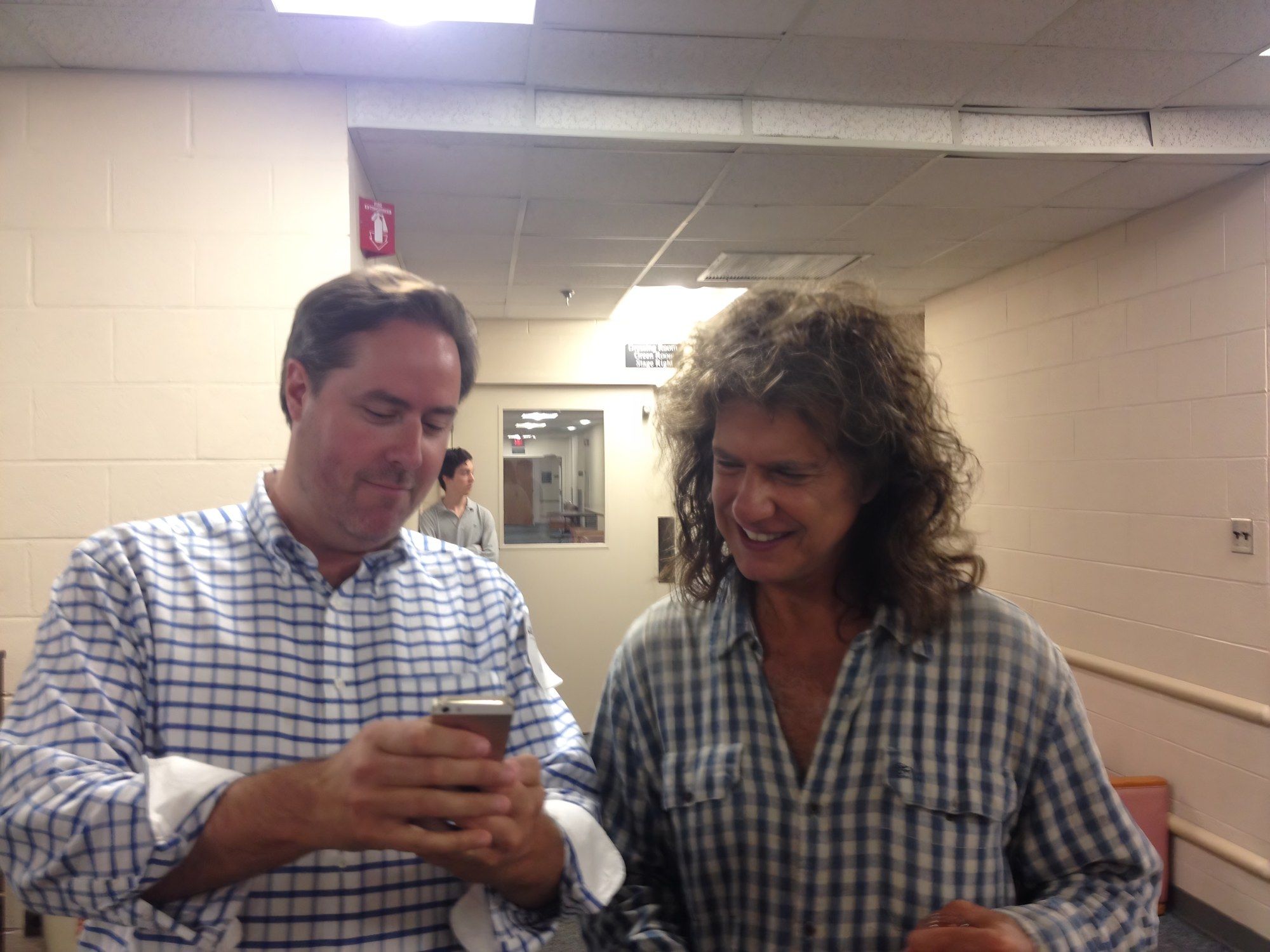 Sean Fenlon and Pat Metheny looking at a phone together
